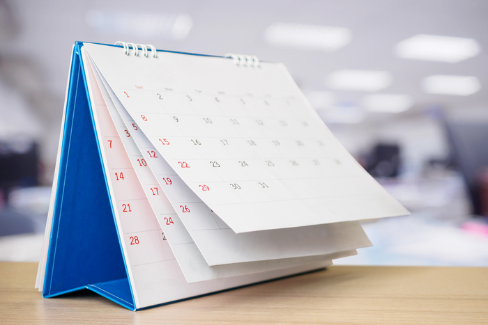 na zdjęciu kalendarz stojący na biurku w dużym biurze